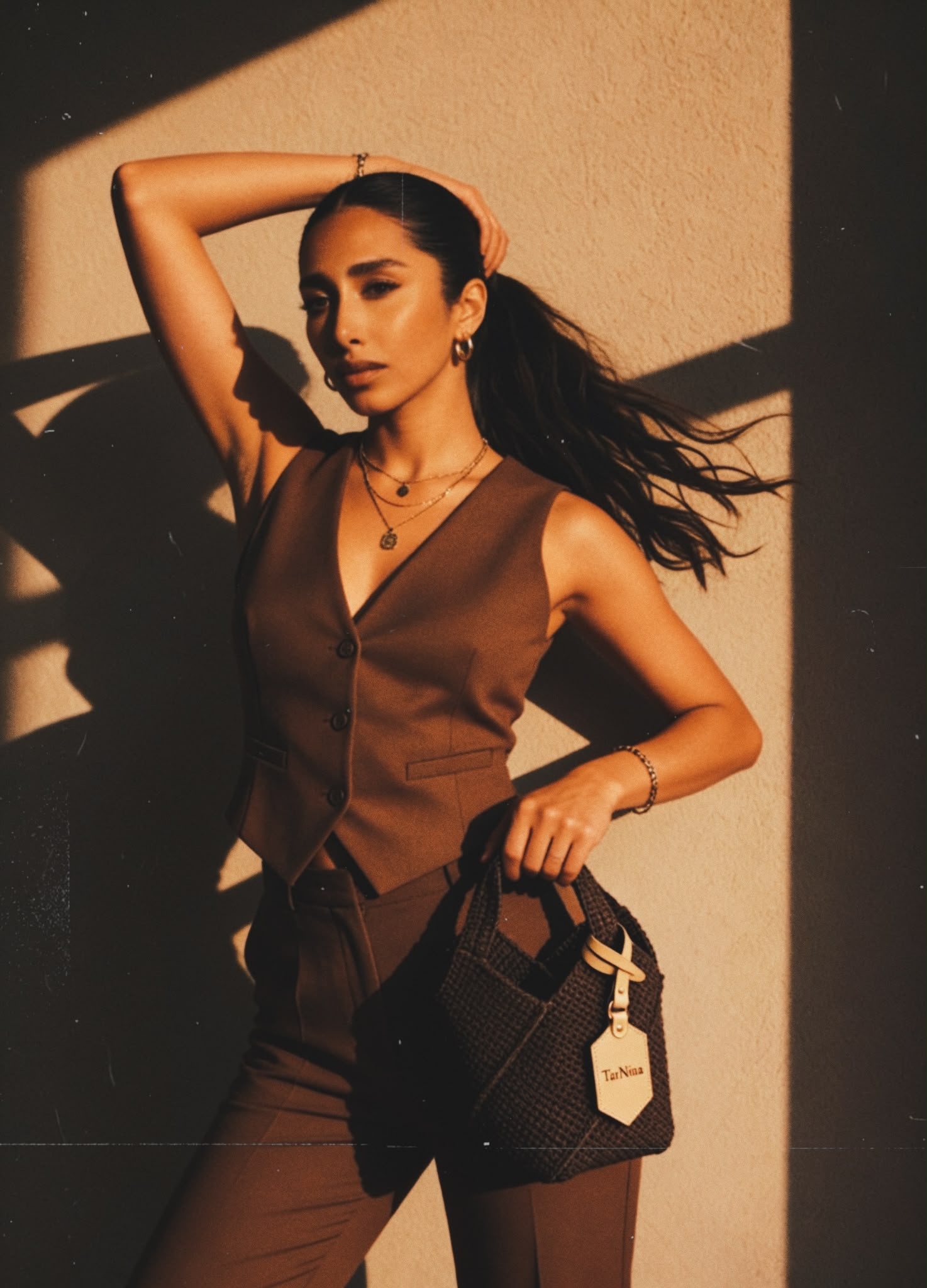 Nina carrying a handcrafted TarNina bag in warm golden light — editorial campaign image showcasing timeless feminine style